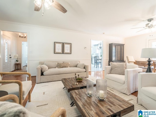 living room with ornamental molding, ceiling fan, and light hardwood / wood-style flooring