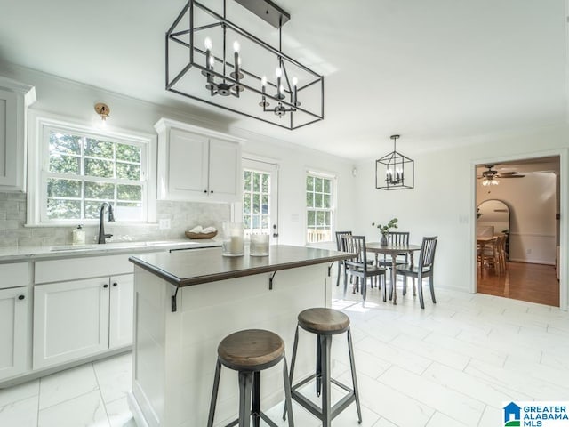 kitchen with decorative backsplash, a center island, and white cabinets