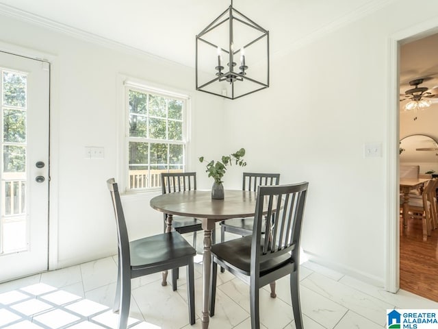 dining space with ornamental molding and ceiling fan