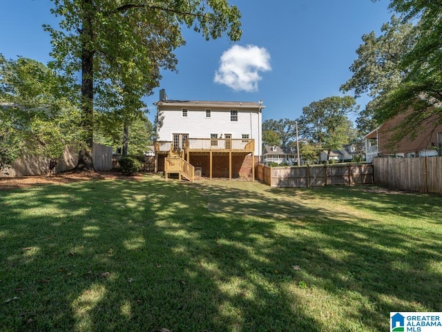 rear view of property with a wooden deck and a yard