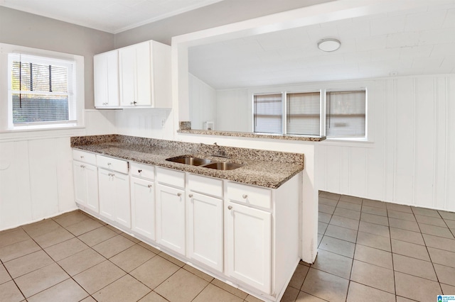 kitchen featuring sink, white cabinetry, kitchen peninsula, and a healthy amount of sunlight