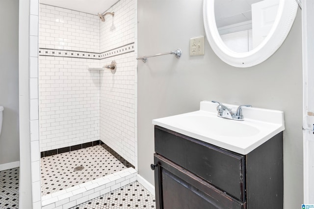 bathroom featuring vanity, tile patterned floors, and tiled shower