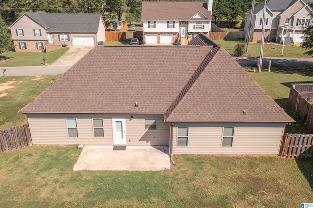 rear view of house with a patio, a garage, and a lawn