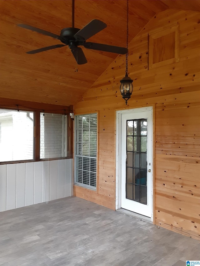 unfurnished sunroom featuring lofted ceiling, wood ceiling, and a wealth of natural light