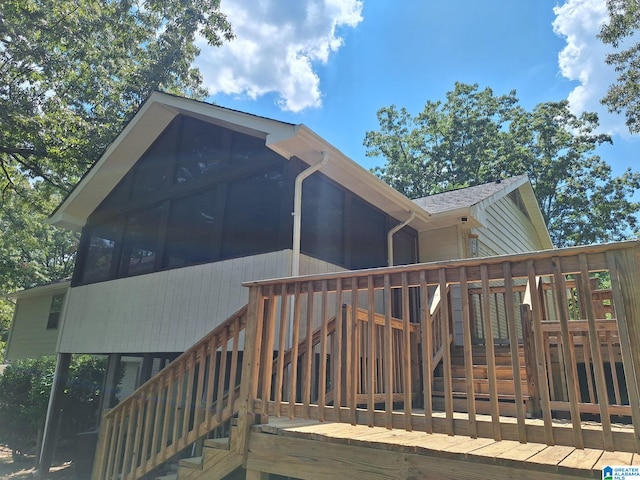 back of property featuring a deck and a sunroom