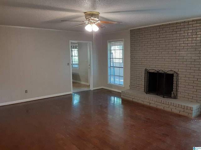 unfurnished living room with a fireplace, ornamental molding, dark hardwood / wood-style flooring, and a textured ceiling