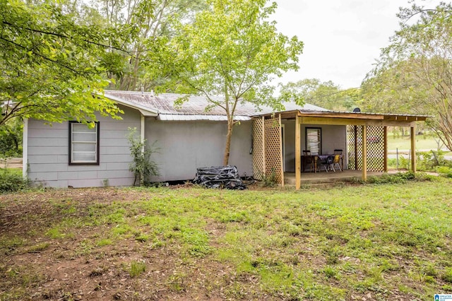 back of house featuring a lawn and a patio area