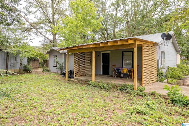 rear view of property featuring a patio area and a yard