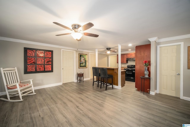 interior space featuring black range with electric stovetop, hardwood / wood-style floors, a kitchen bar, and ceiling fan