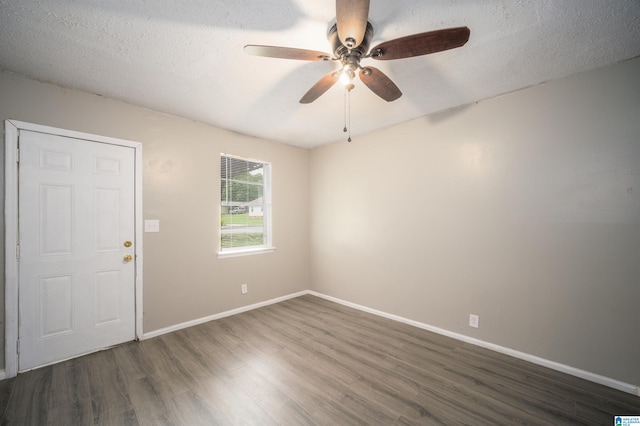 unfurnished room with ceiling fan, a textured ceiling, and dark hardwood / wood-style flooring