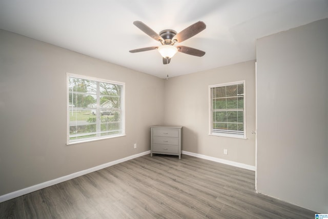 spare room with hardwood / wood-style floors and ceiling fan