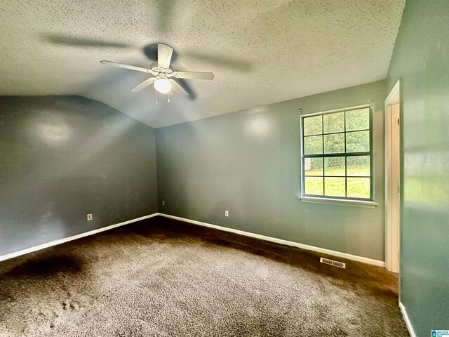 carpeted spare room featuring a textured ceiling, lofted ceiling, and ceiling fan