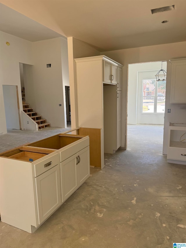 kitchen with white cabinets and decorative light fixtures