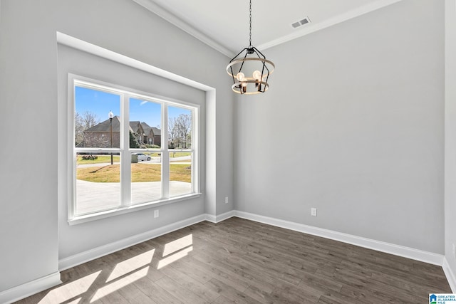 unfurnished room with crown molding, dark wood finished floors, visible vents, a notable chandelier, and baseboards