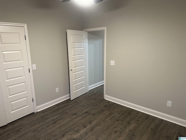 unfurnished bedroom featuring ceiling fan and dark wood-type flooring