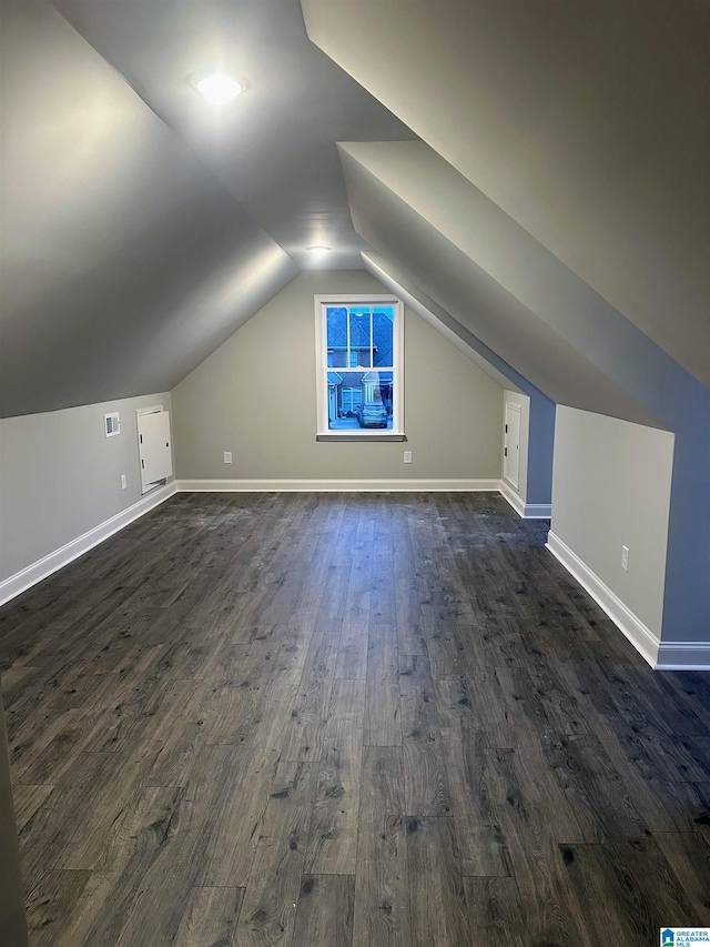 bonus room with lofted ceiling and dark hardwood / wood-style floors