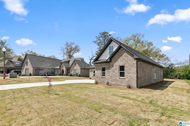 craftsman house featuring a front yard, brick siding, and driveway