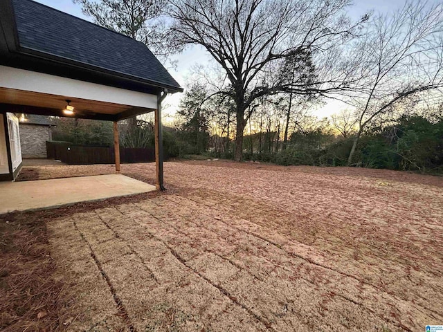 yard at dusk featuring a patio area