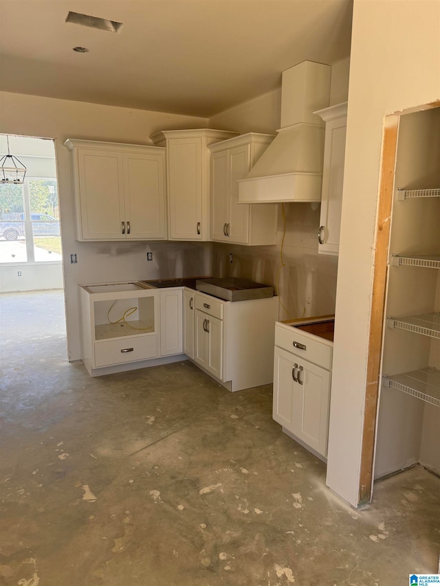 kitchen featuring white cabinets and custom exhaust hood