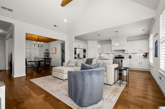 living room featuring wood-type flooring, an inviting chandelier, and plenty of natural light