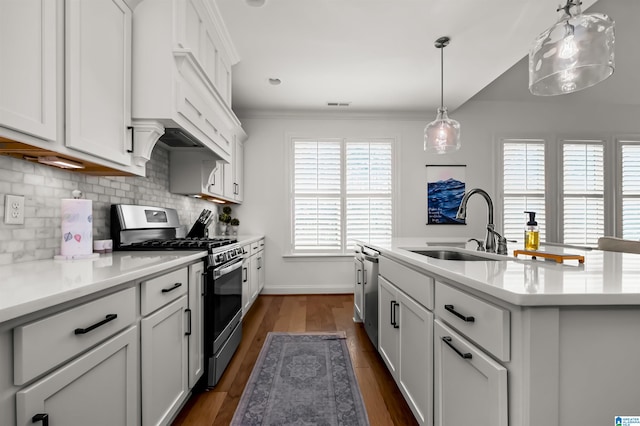 kitchen with white cabinets, sink, decorative light fixtures, appliances with stainless steel finishes, and dark hardwood / wood-style flooring