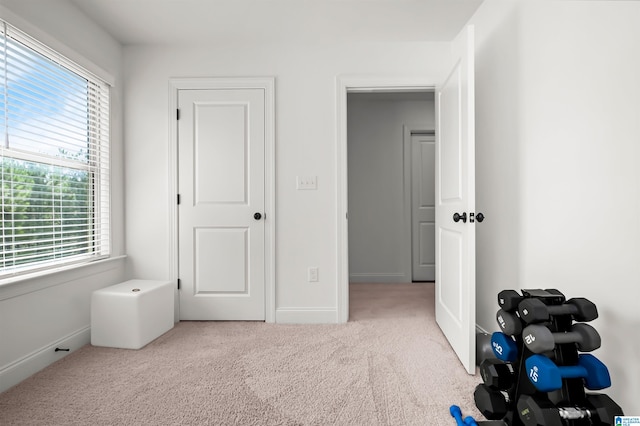 unfurnished bedroom featuring light carpet and multiple windows