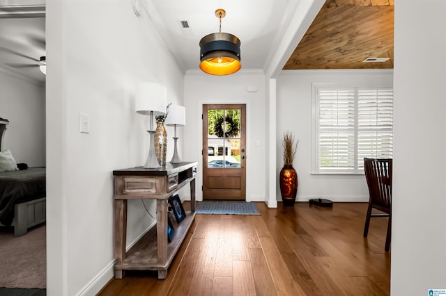 foyer with crown molding, ceiling fan, plenty of natural light, and dark hardwood / wood-style flooring