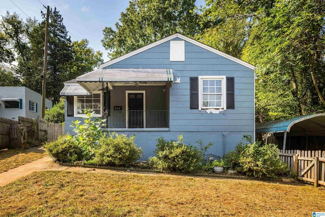 bungalow-style home with a front yard and a carport