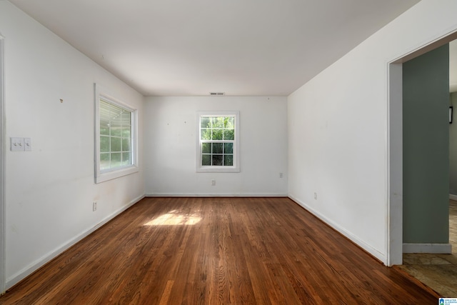 unfurnished room with dark hardwood / wood-style flooring