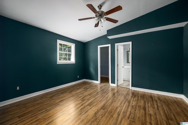 unfurnished bedroom with ceiling fan, lofted ceiling, ensuite bathroom, a spacious closet, and hardwood / wood-style floors