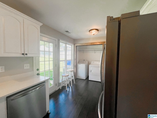 kitchen with washer and clothes dryer, white cabinets, appliances with stainless steel finishes, and dark hardwood / wood-style flooring