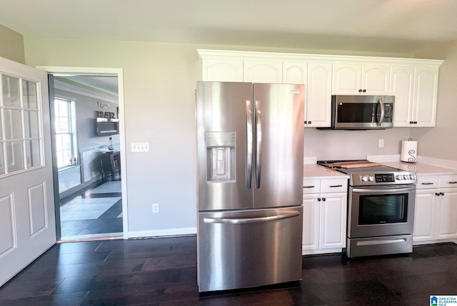 kitchen with stainless steel appliances, white cabinetry, and dark hardwood / wood-style flooring