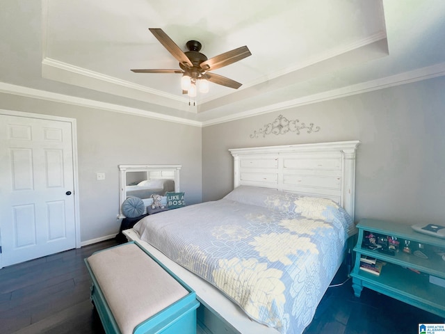 bedroom featuring ceiling fan, a raised ceiling, dark hardwood / wood-style floors, and ornamental molding