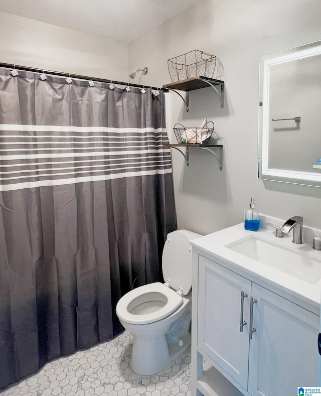 bathroom featuring a shower with shower curtain, tile patterned floors, vanity, and toilet