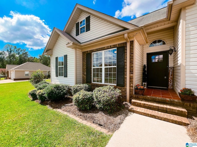 entrance to property featuring a garage and a lawn