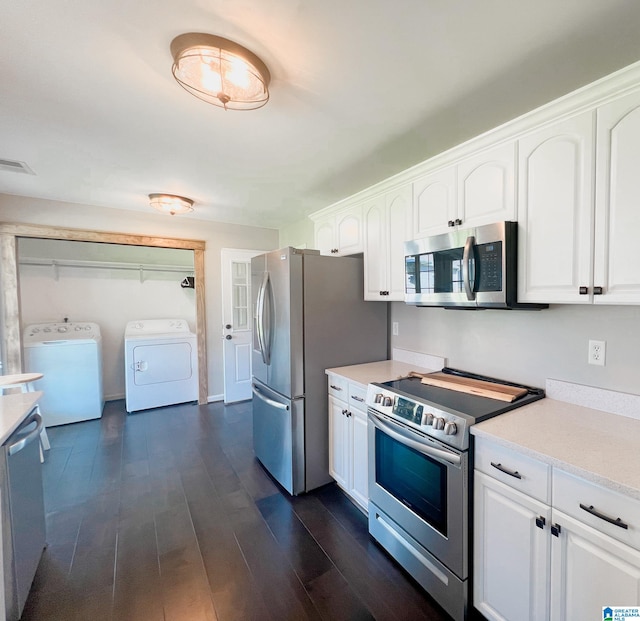 kitchen featuring appliances with stainless steel finishes, washer and clothes dryer, dark wood-type flooring, and white cabinets