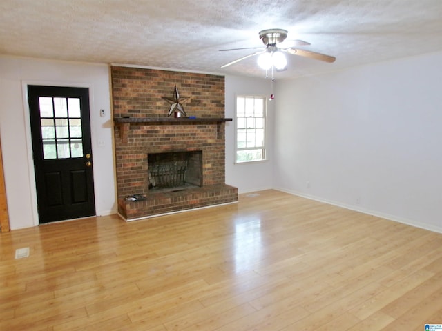 unfurnished living room featuring a textured ceiling, light hardwood / wood-style flooring, and plenty of natural light