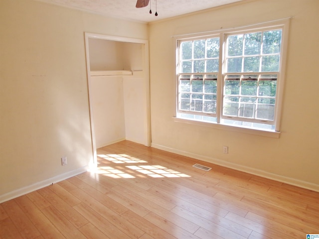 unfurnished bedroom with light hardwood / wood-style flooring, a closet, ceiling fan, and a textured ceiling