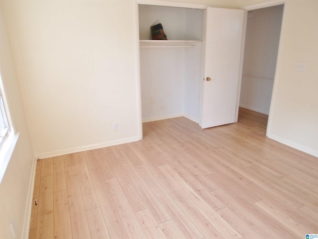 unfurnished bedroom with light wood-type flooring and a closet