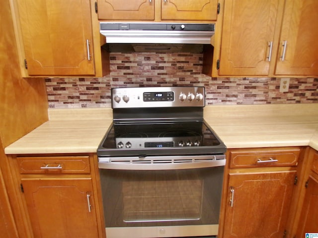 kitchen featuring stainless steel electric stove and tasteful backsplash