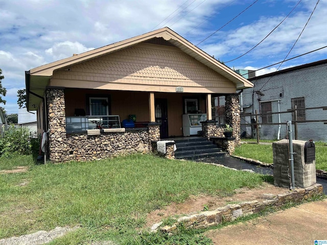 bungalow-style house featuring a front lawn and covered porch