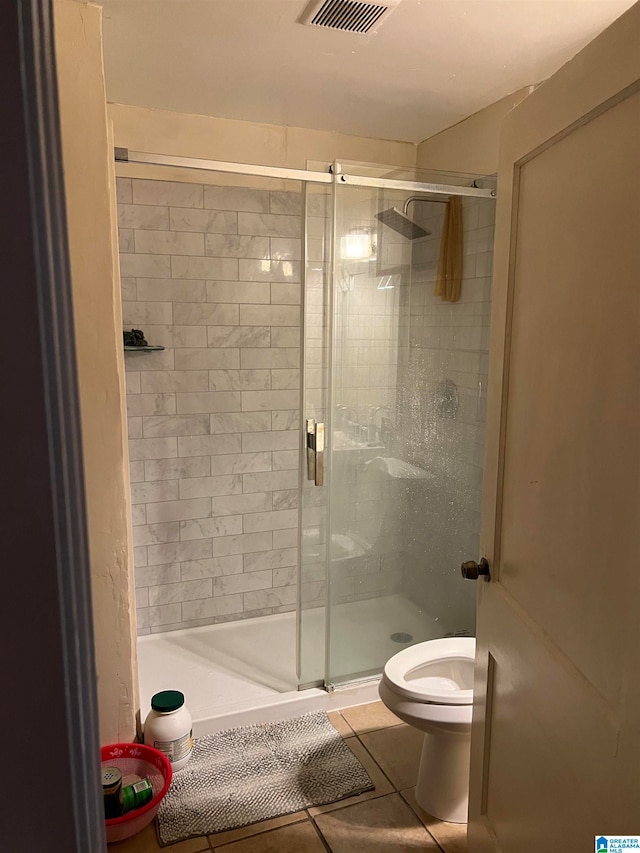 bathroom with walk in shower, tile patterned flooring, and toilet