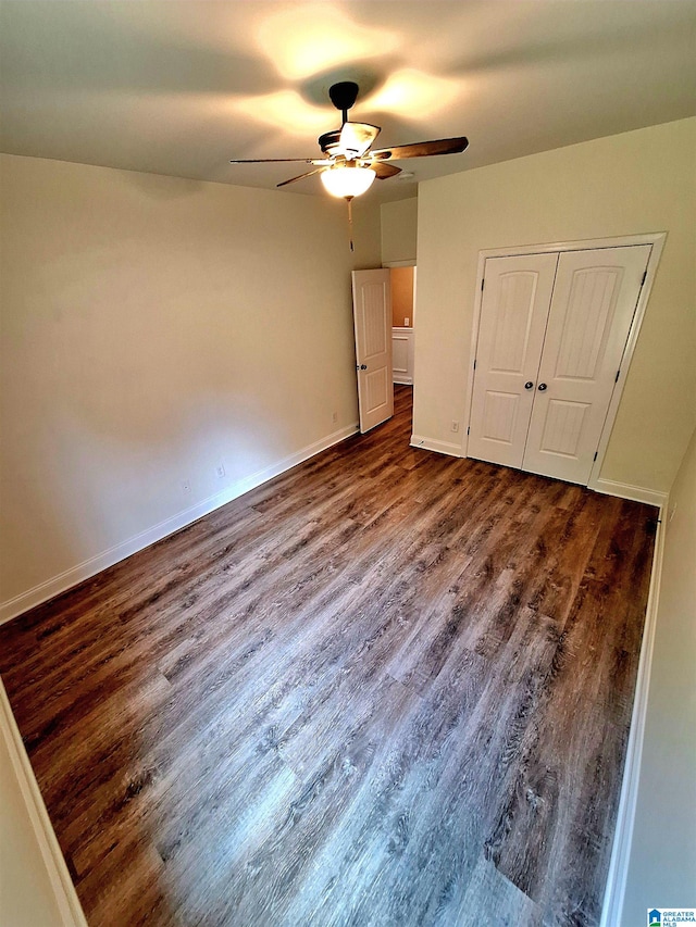 unfurnished bedroom featuring dark hardwood / wood-style floors, ceiling fan, and a closet