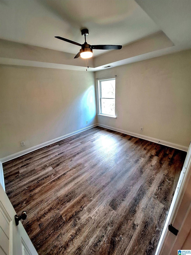 spare room featuring dark hardwood / wood-style flooring and ceiling fan