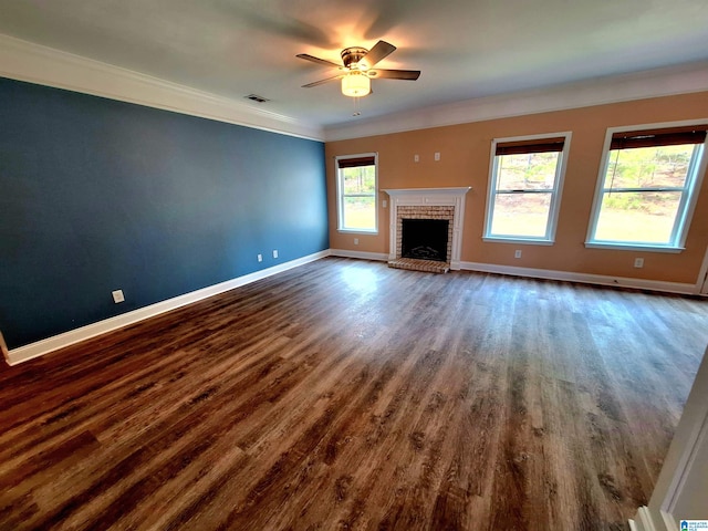 unfurnished living room featuring ceiling fan, ornamental molding, a fireplace, and dark wood-type flooring