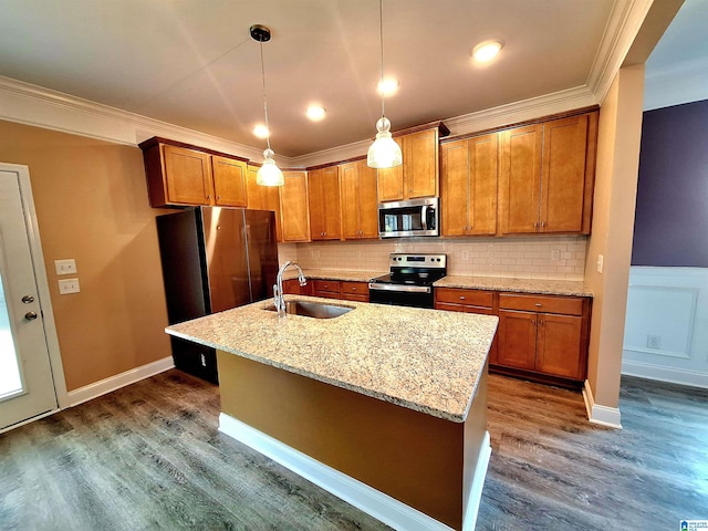 kitchen featuring dark wood-type flooring, light stone countertops, stainless steel appliances, a kitchen island with sink, and sink