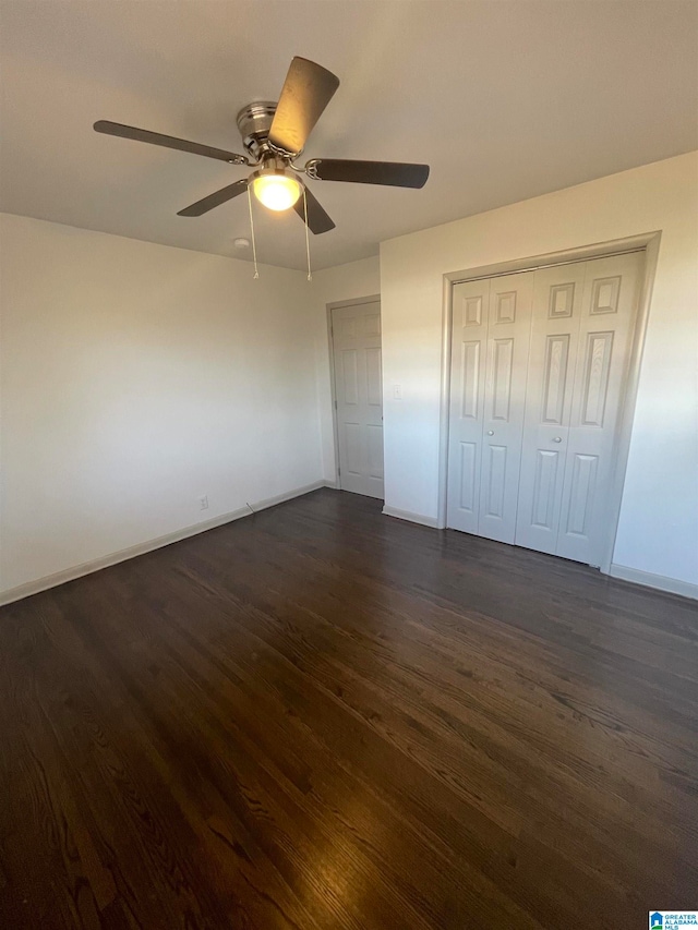 unfurnished bedroom with a closet, ceiling fan, and dark hardwood / wood-style flooring