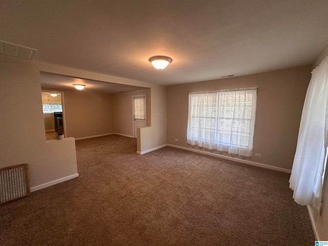 carpeted empty room featuring a wealth of natural light