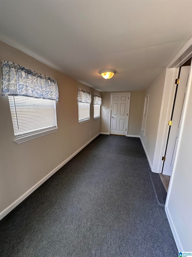 spare room with dark carpet