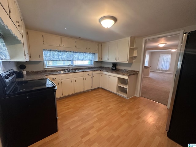 kitchen with stainless steel refrigerator, light hardwood / wood-style flooring, sink, and electric range